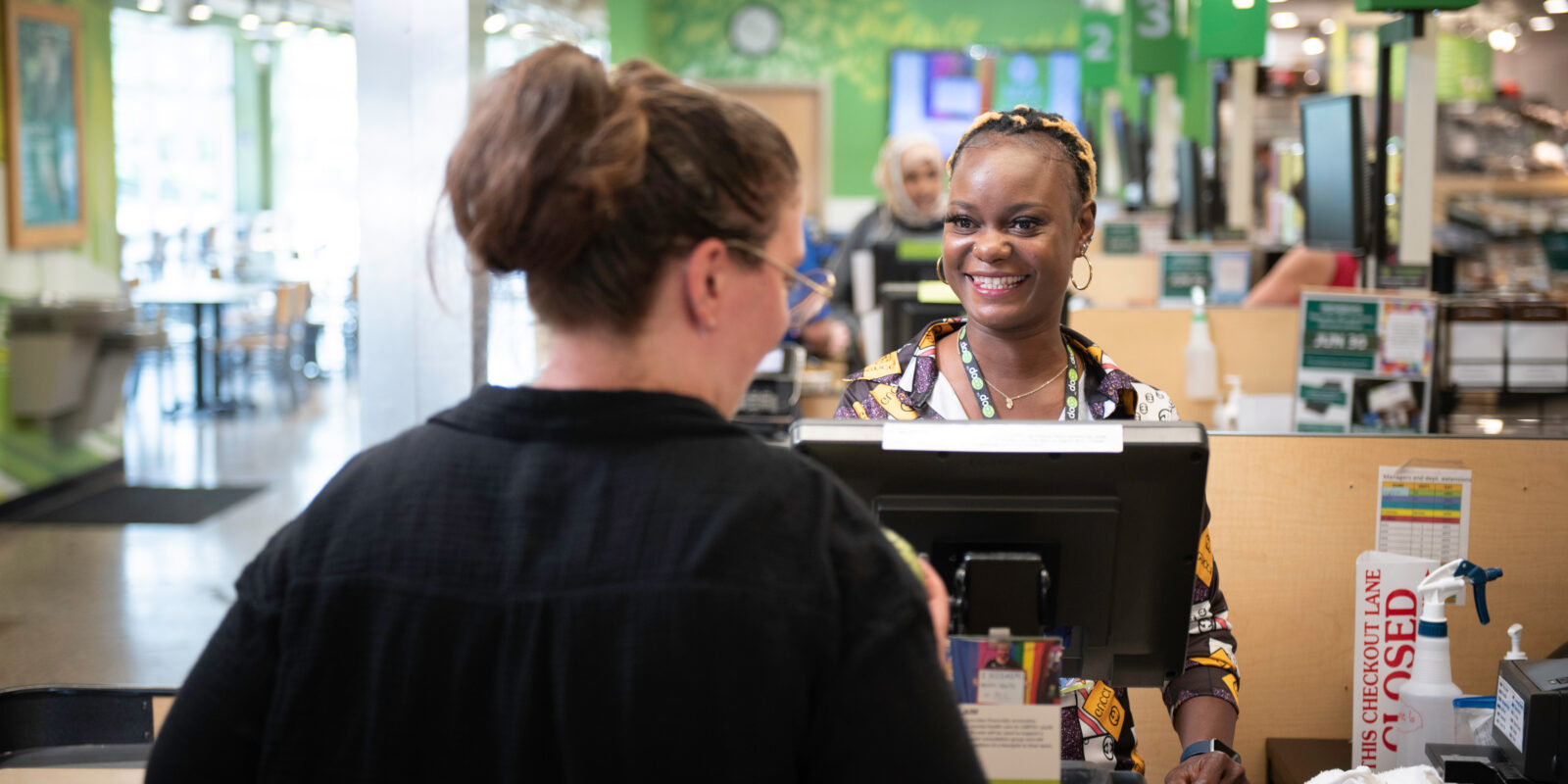 A Seward Co-op staff member helping a customer at the register