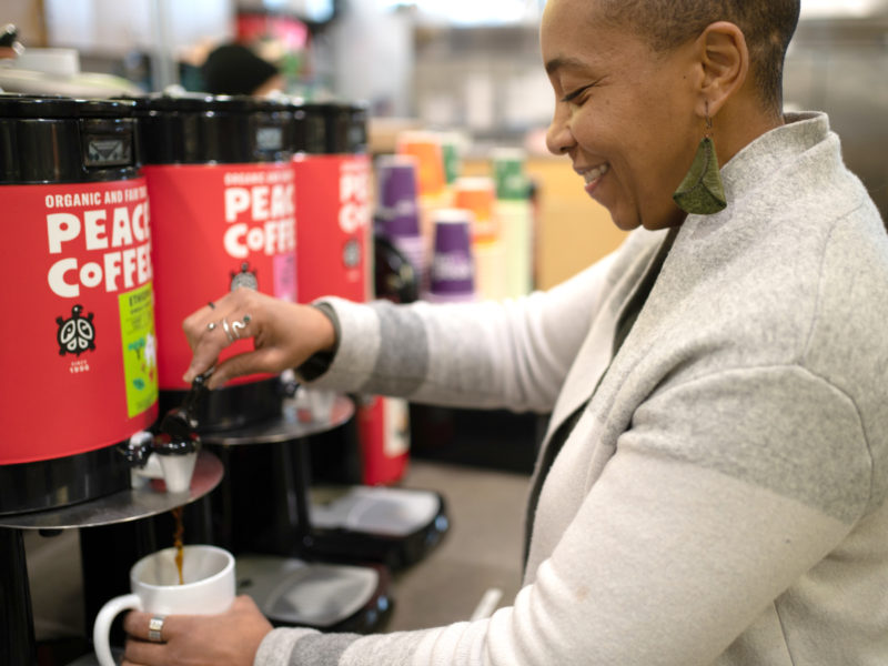 A person getting coffee in a mug at Seward Co-op