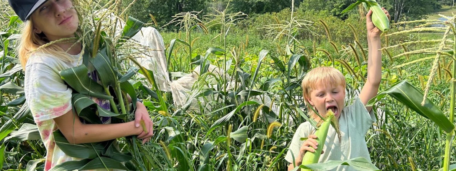 Two kids in a corn field acting silly