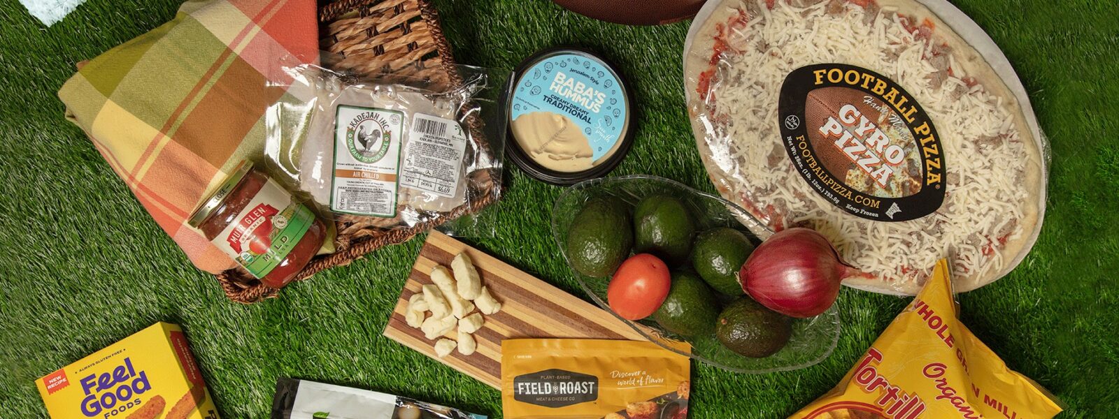 A collection of game day snacks and eats on a grass background