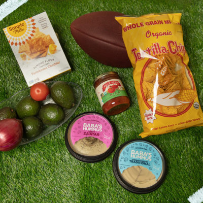 A collection of game day snacks and eats on a grass background