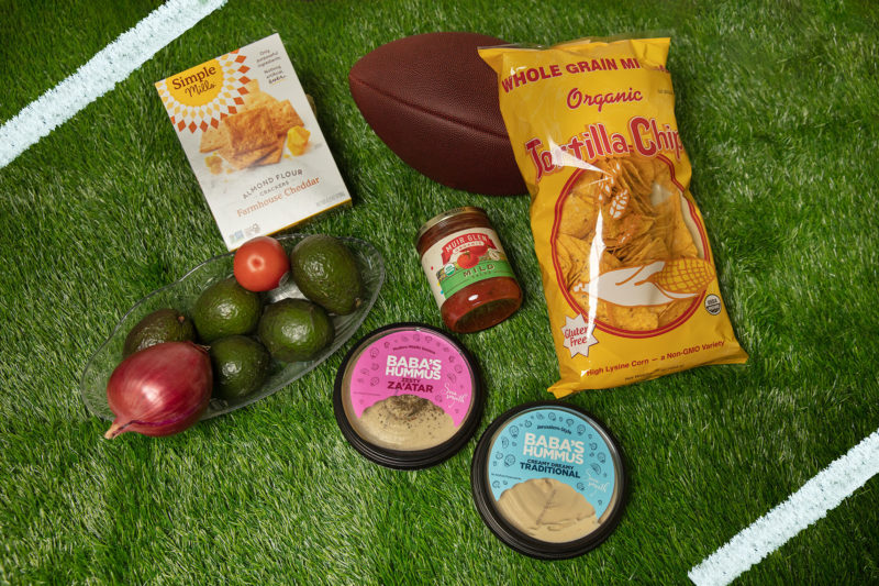 A collection of game day snacks and eats on a grass background