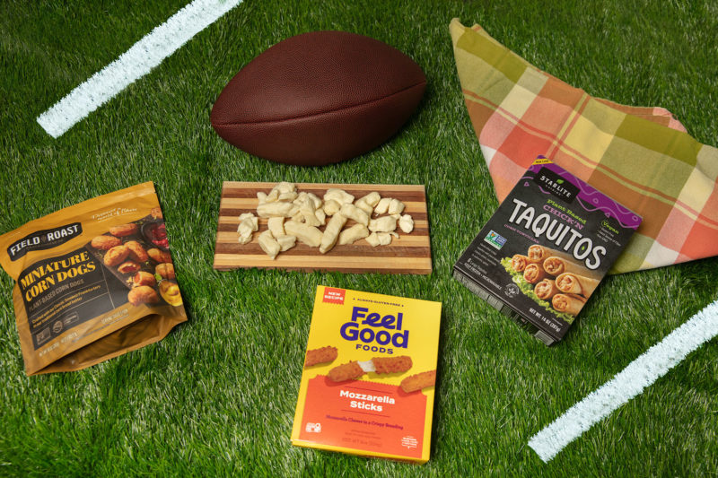 A collection of game day snacks and eats on a grass background