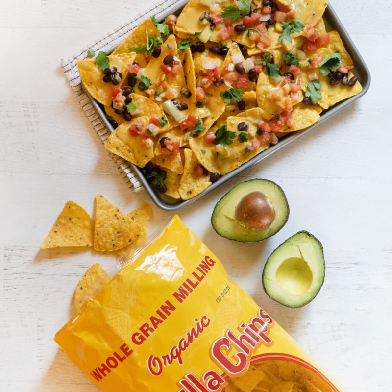 A photo of nachos, avocados, and a bag of tortilla chips