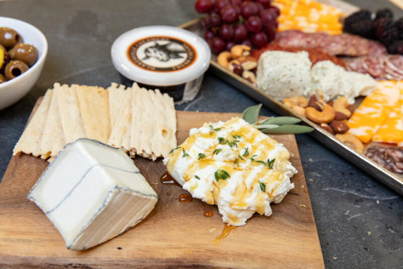 Different cheeses on a cheese board with crackers