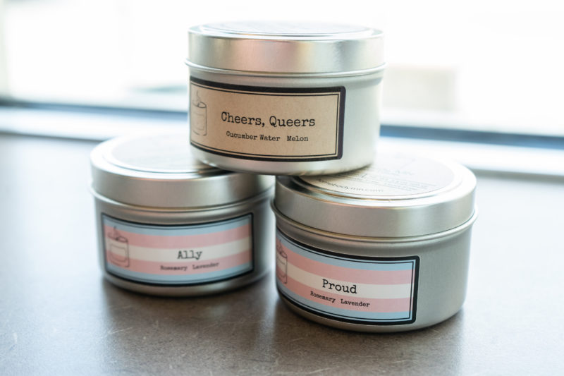 Three tinned candles stacked in a pyramid, reading "Cheers, Queers", "Proud", and "Ally"