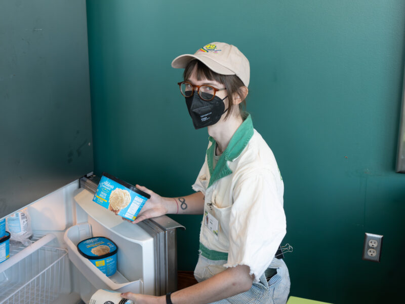 person grabbing ice cream from a freezer