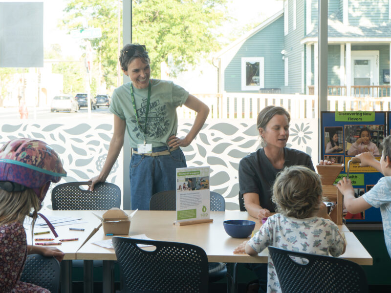 adults and children gathered around a table, smiling