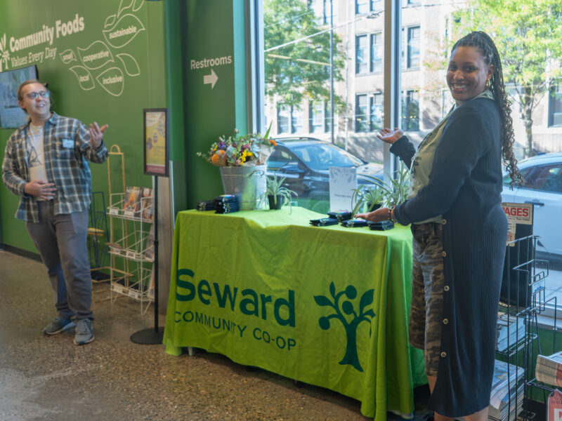 two staff members showing off a Seward Co-op table
