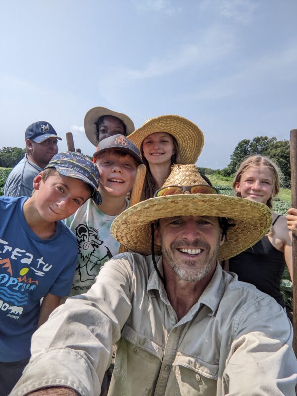 A group of people posing for a picture on a farm