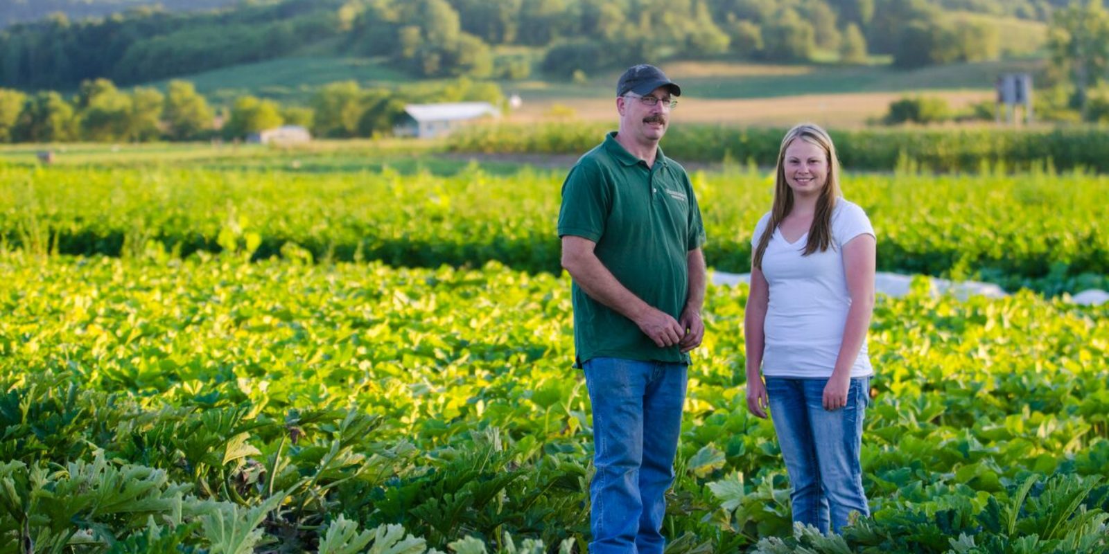 Two people standing in a green field