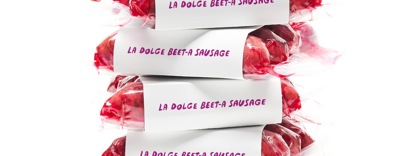 a stack of fuscia beet sausages in packaging