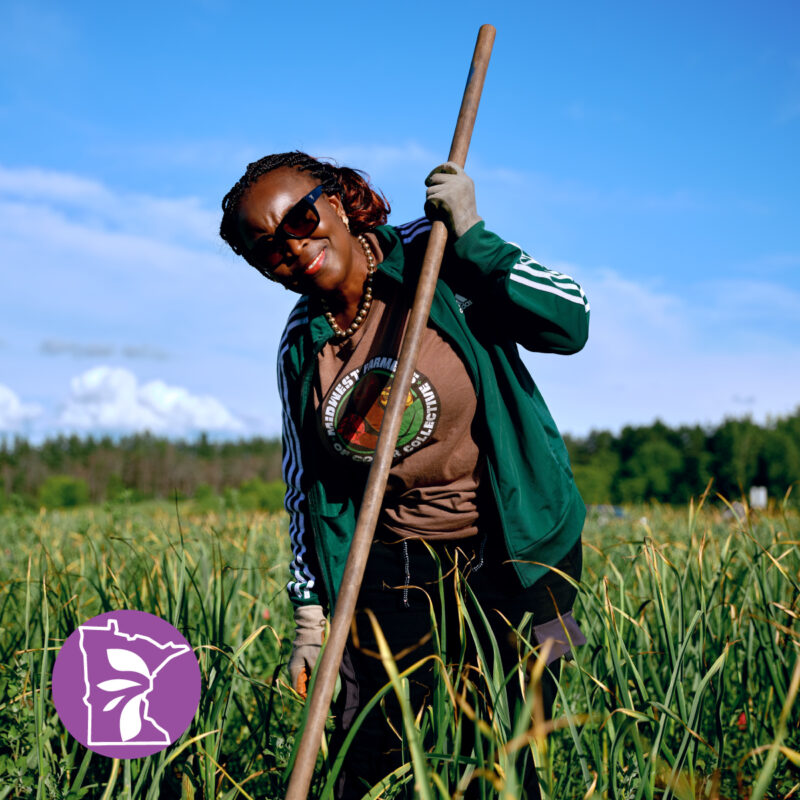 A woman with sunglasses on holding farm equipment