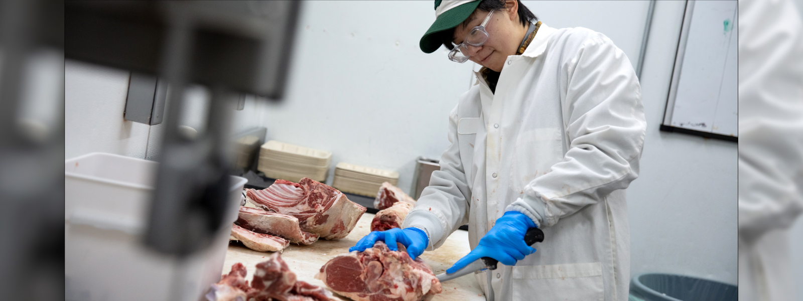 A staff member from Meat and Seafood cutting lamb
