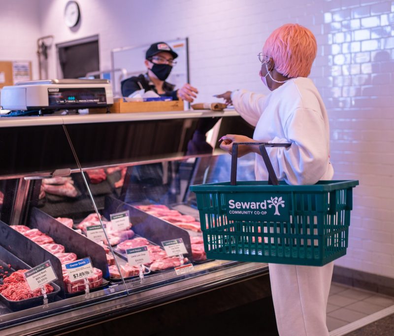 A person getting something from the Meat and Seafood counter