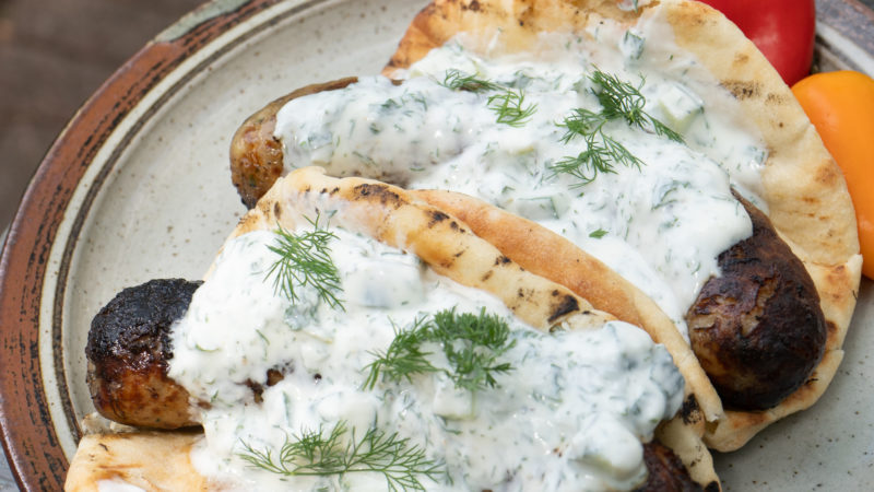 Sausages in bread covered in yogurt sauce