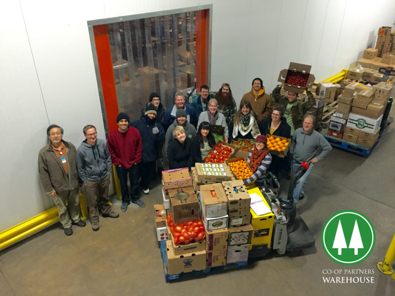 A group of people standing in a warehouse and smiling