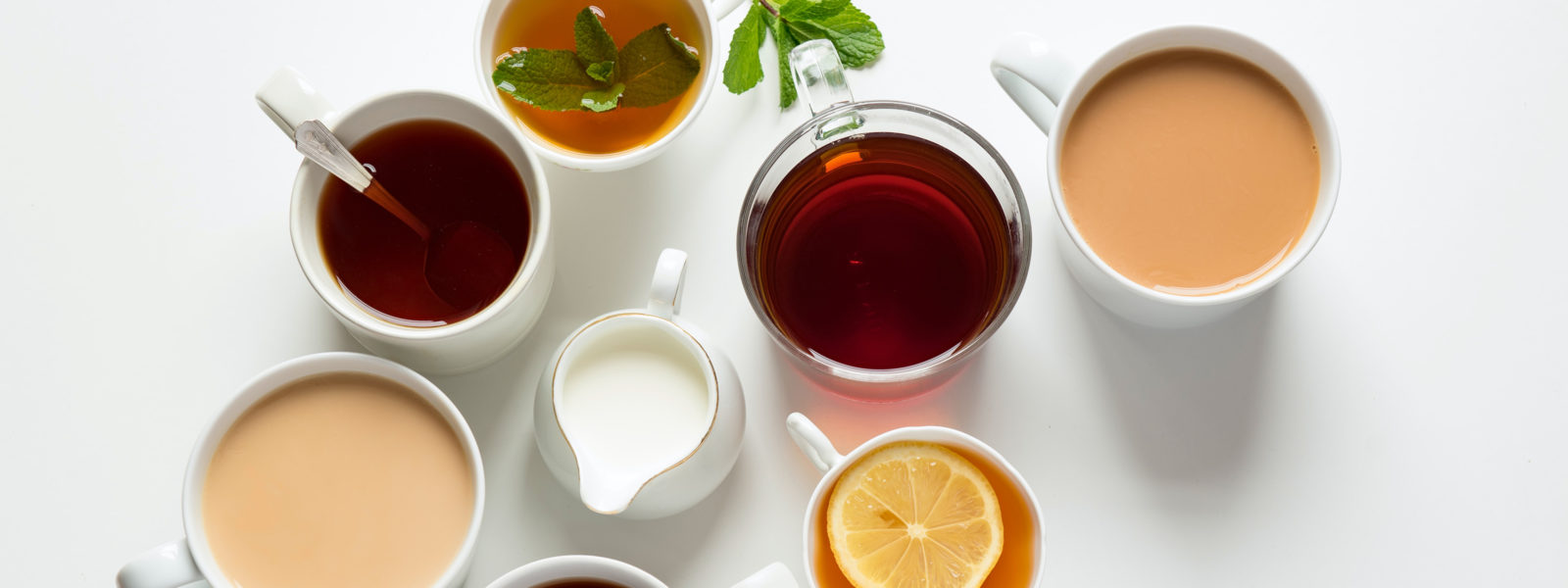 An overhead photo of cups of tea on a white background