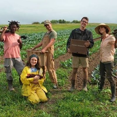 A group of people posing in an agricultural field