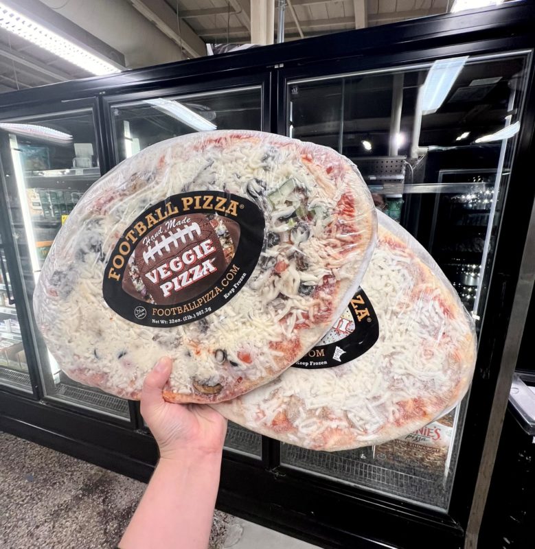 A hand holding up two Football Pizzas