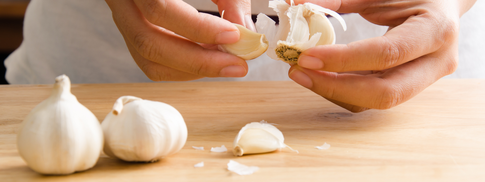 Two hands separating garlic cloves
