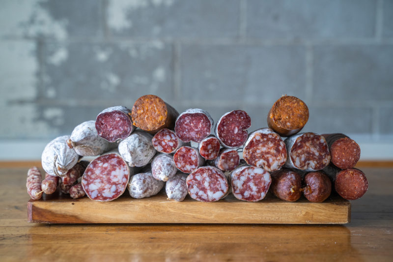 A collection of salumi stacked atop one another