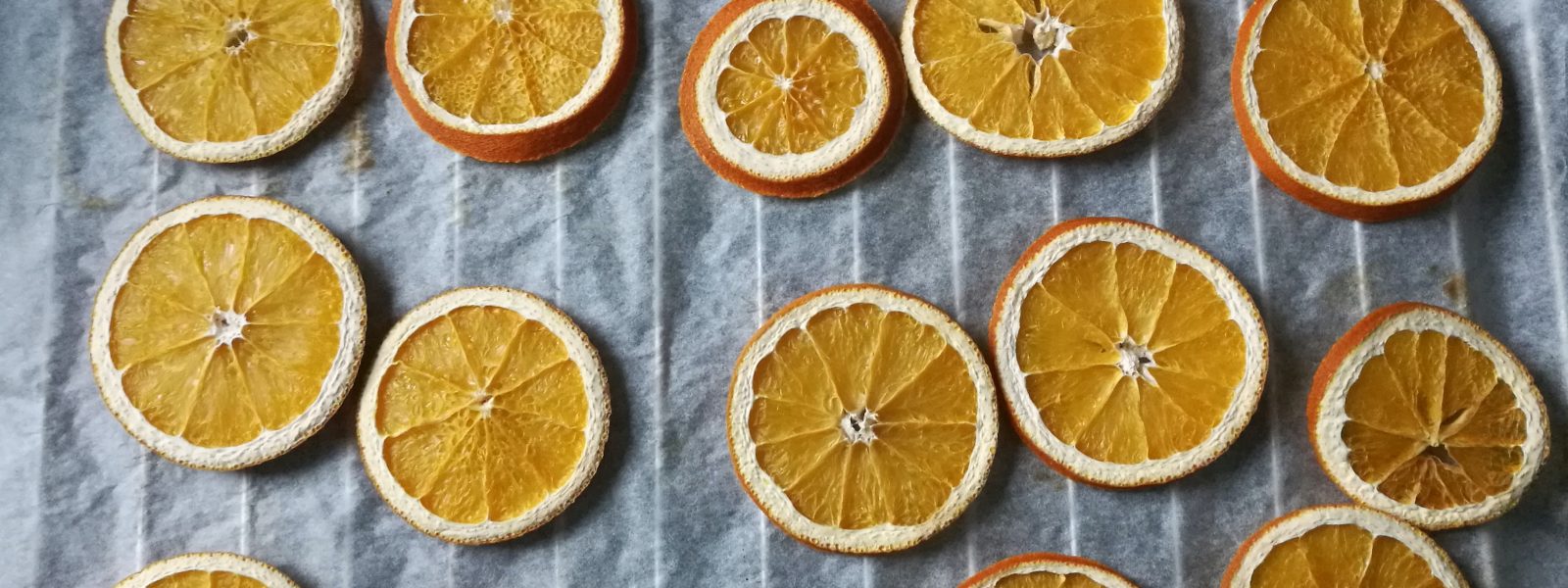 dried orange slices on white parchment paper