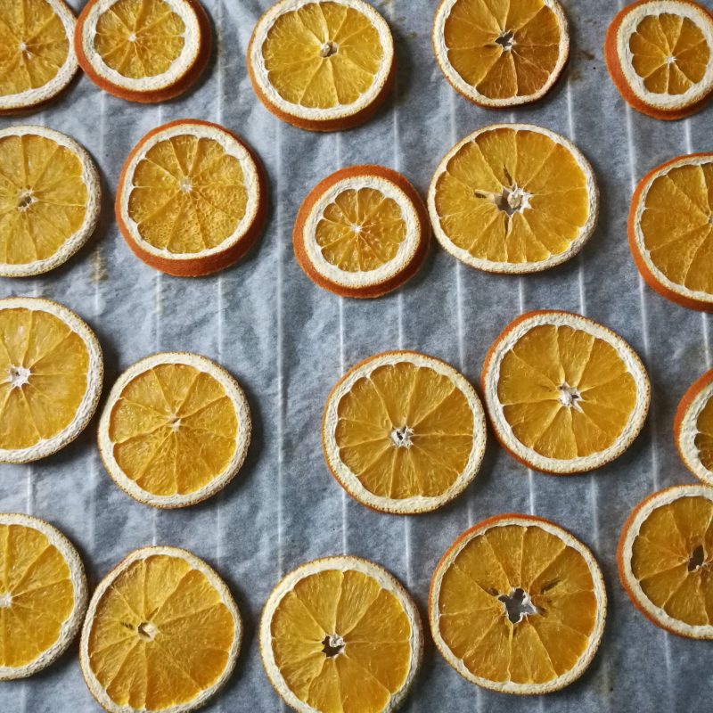 dried orange slices on white parchment paper