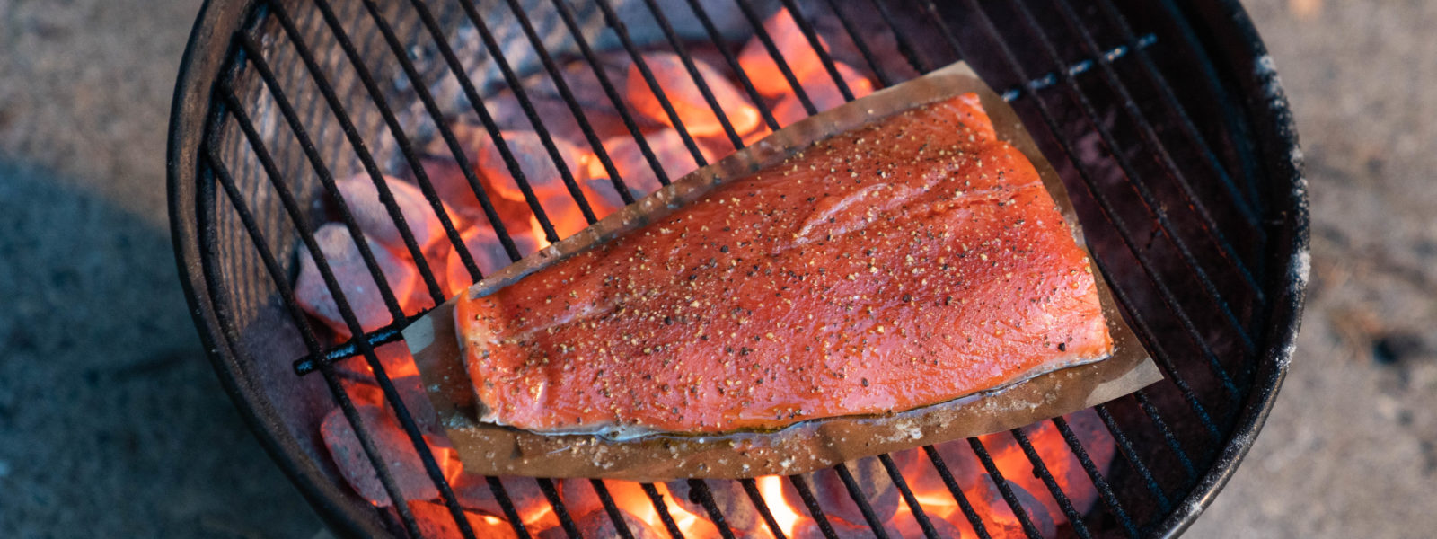 A piece of salmon cooking on a grill
