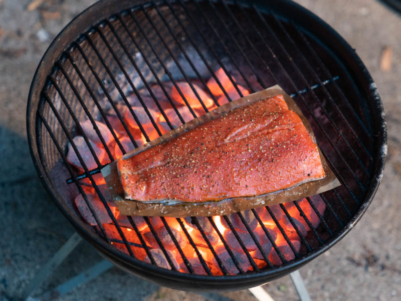 A piece of salmon cooking on a grill