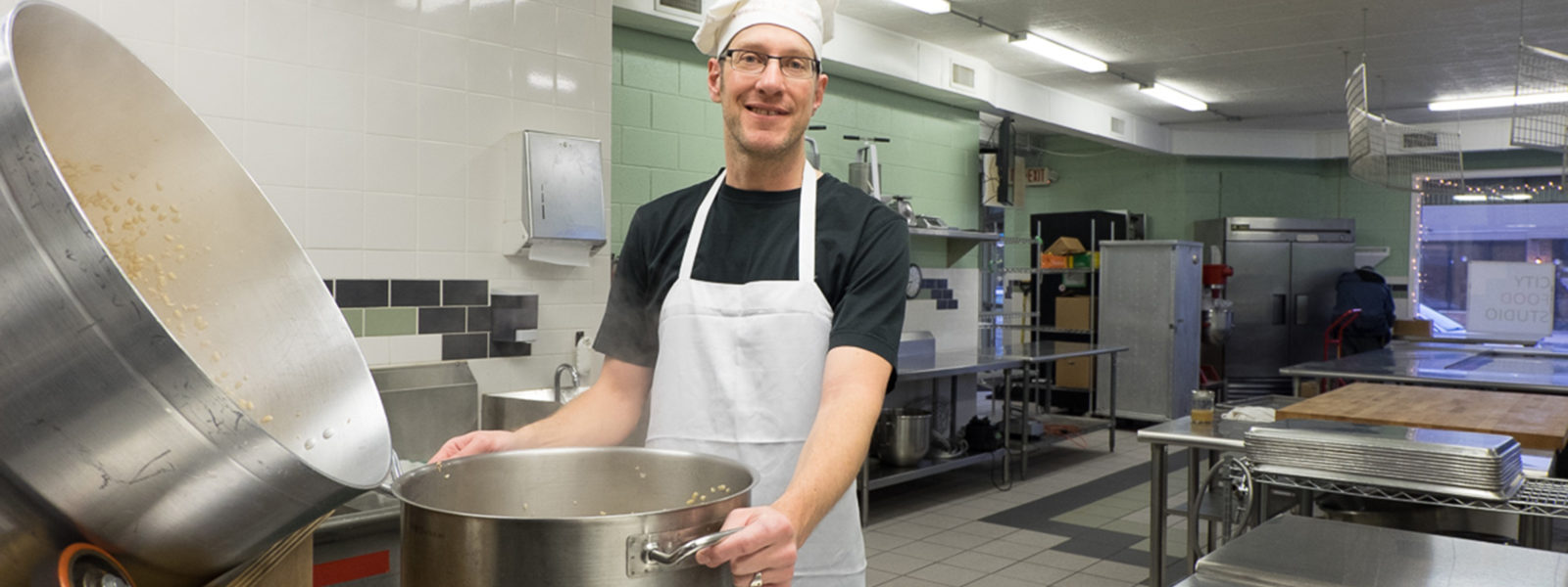 A photo of someone in a kitchen with a large pot