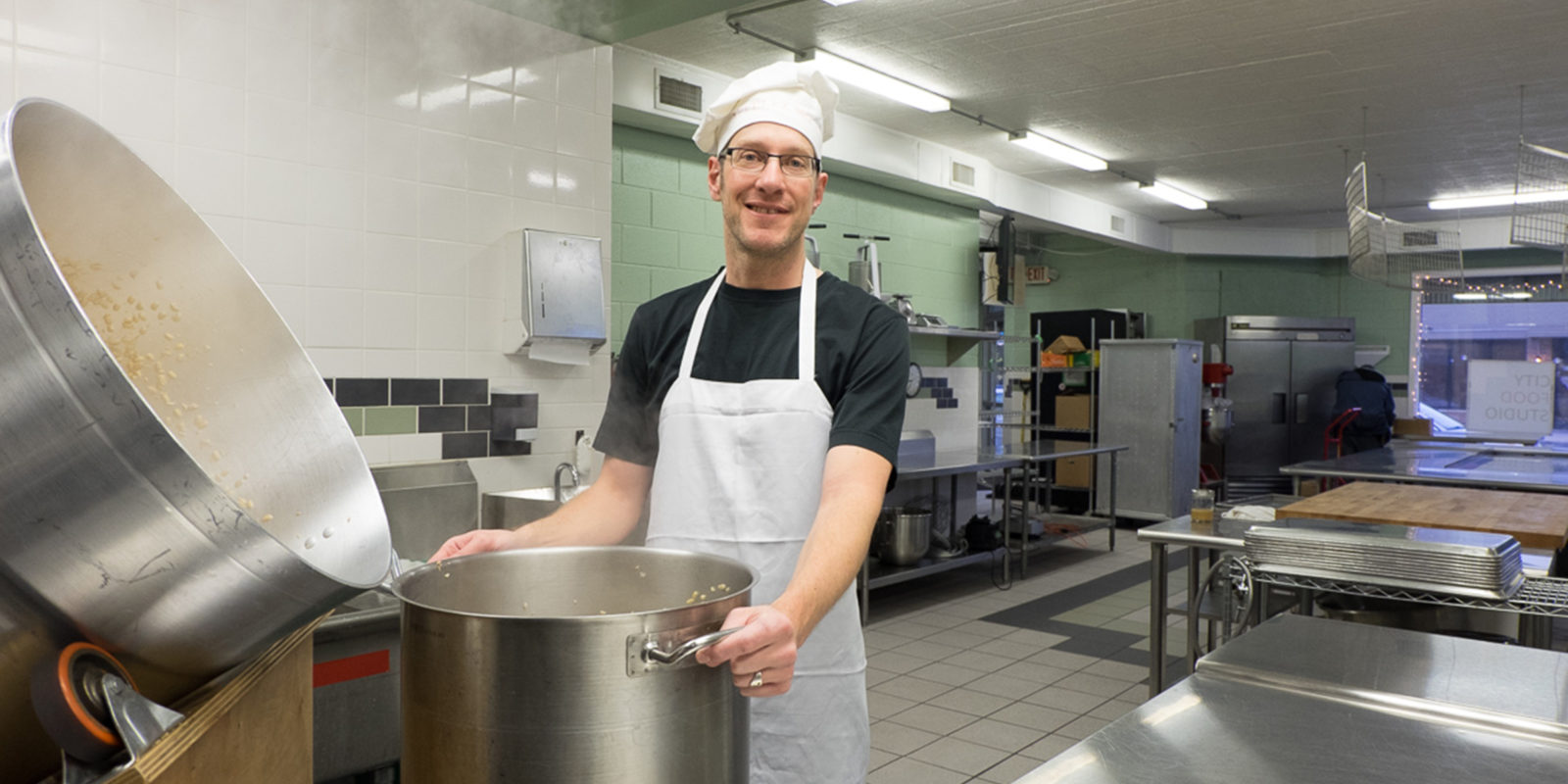 A photo of someone in a kitchen with a large pot