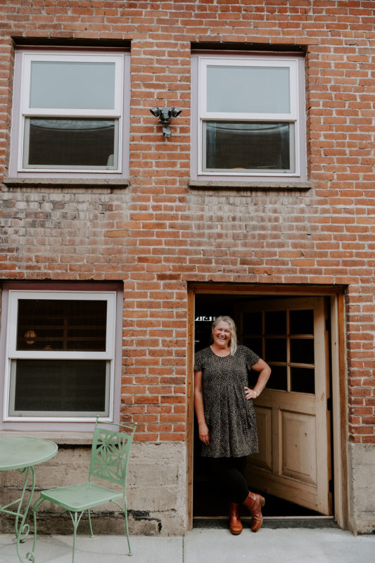 A person standing in the doorway of a brick house
